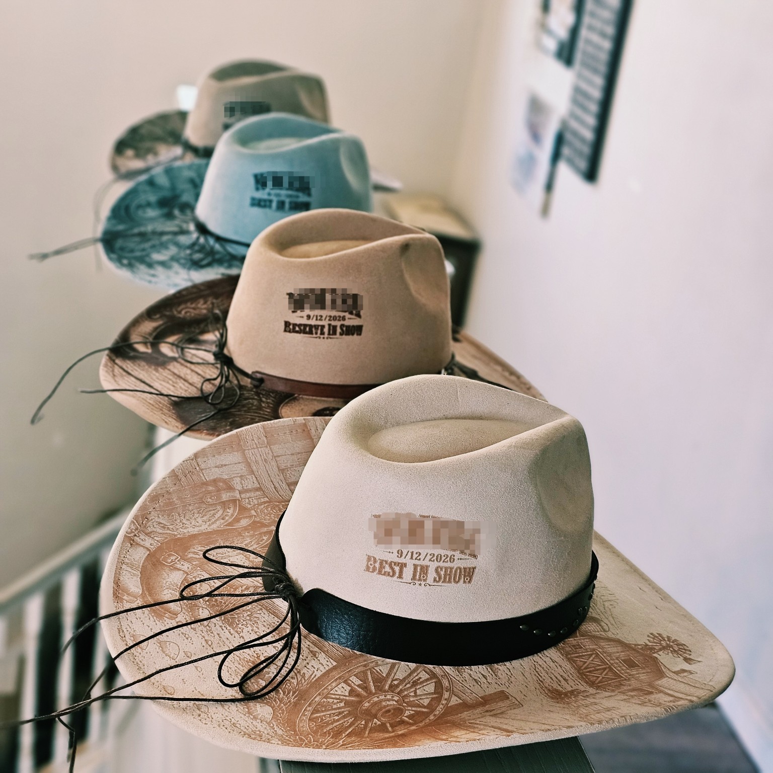 Four engraved western hats with Best in Show and Reserve in Show wording; original obscured details preserved